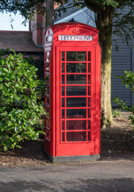 BT Telephone box among bushes in England CHESTER, UK - 21 FEBRUARY 2019: British Telecom bright red phonebox among bushes in England british telecom photos stock pictures, royalty-free photos & images