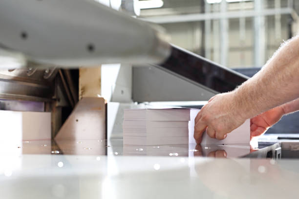 istock Bindery. Paper trimming on a guillotine. 1135328015