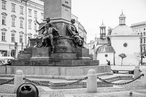 Krakow, Poland - October 8, 2018: Adam Mickiewicz Monument in Krakow is one of the best known bronze monuments in Poland, and a favourite meeting place at the Main Market Square in the Old Town (Stare Miasto) district of Kraków. The statue of Adam Mickiewicz, the greatest Polish Romantic poet of the 19th century, was unveiled on June 16, 1898, on the 100th anniversary of his birth, in the presence of his daughter and son. It was designed by Teodor Rygier.