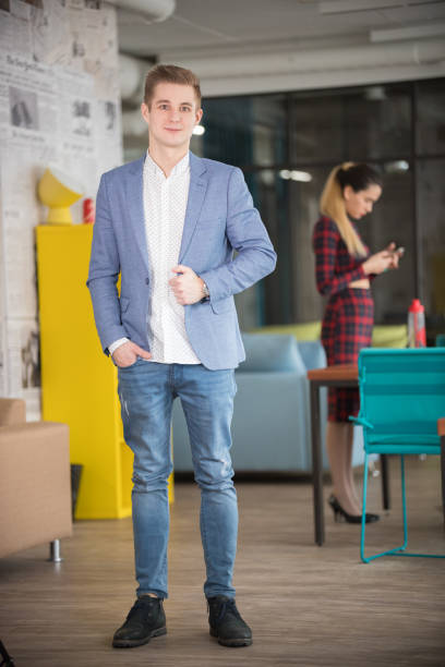 istock Young businessman in blue jacket standing at office 1135329802