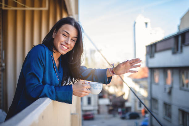 istock Cheerful neighbor waving while drinking coffee on a terrace 1135331108