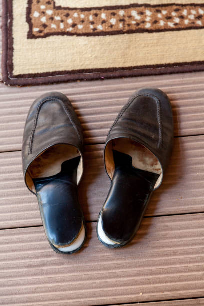 istock Leather slippers stand in front of carpet 1135332978