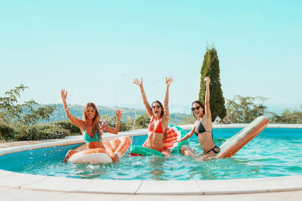 istock Three girls relaxing and having fun in the pool 1135334121