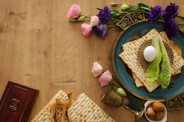 istock Pesah celebration concept (jewish Passover holiday). Traditional book with text in hebrew: Passover Haggadah (Passover Tale) and plate with word MATZAH 1135337724