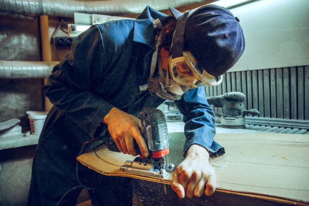 istock Carpenter using circular saw for cutting wooden boards. 1135339756