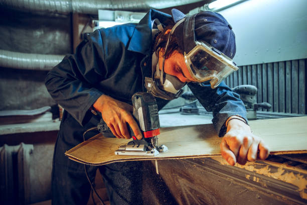 istock Carpenter using circular saw for cutting wooden boards. 1135339769