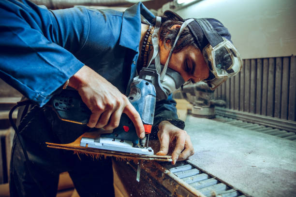 istock Carpenter using circular saw for cutting wooden boards. 1135339776