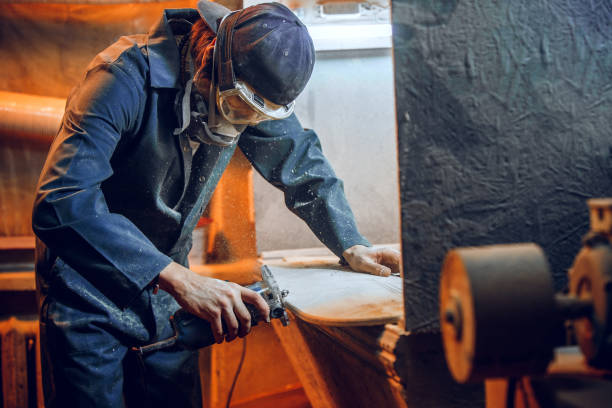 istock Carpenter using circular saw for cutting wooden boards. 1135339811