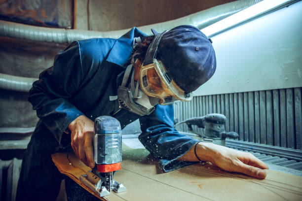 istock Carpenter using circular saw for cutting wooden boards. 1135339825