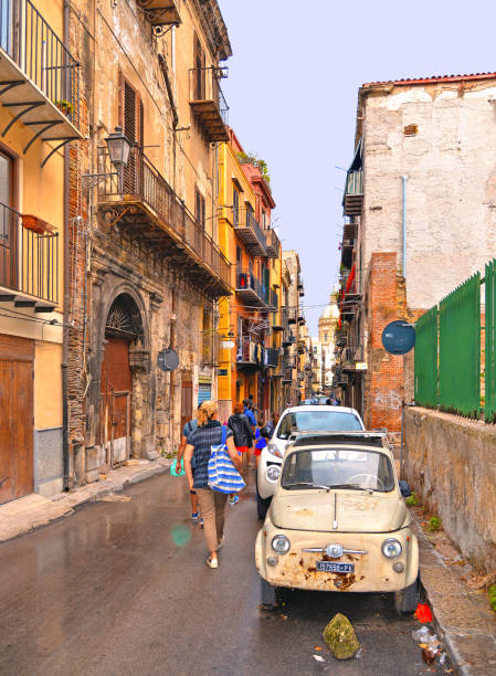 sicilia italia-antigua calle estrecha con la gente y el coche vintage fiat 500 y antiguos edificios clásicos en palermo en el sur de italia - sicily fiat old car fotografías e imágenes de stock