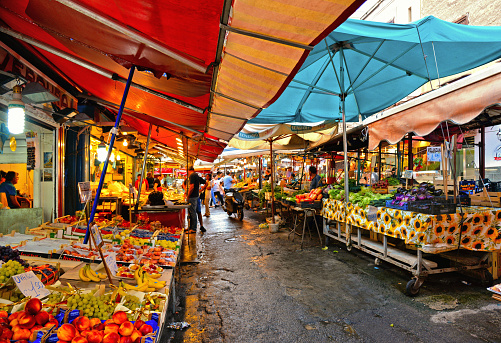 PALERMO, ITALY 22.08.2018. People on the street at local market Ballarò with fresh vegetables, fruits, all kind of food and colorful umbrellas in Palermo, Italy.  island of Sicily.