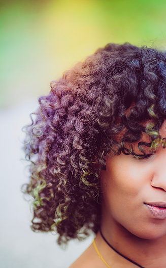 Close up of a young African American woman. outdoors. Natural curly hair