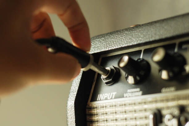 istock hand put cable audio jackguitar in amplifier 1135342215