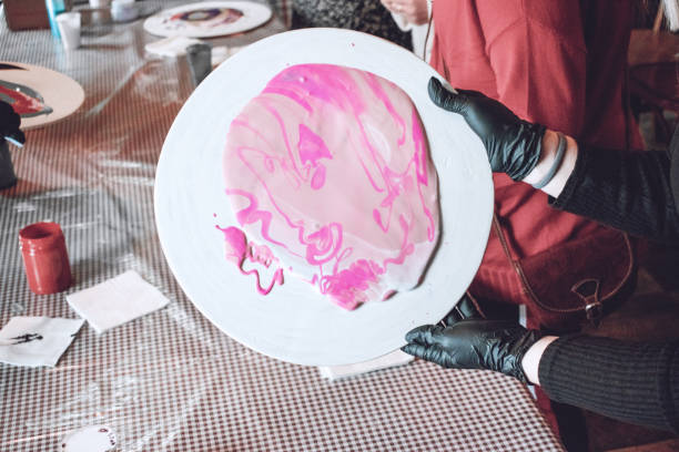istock Fluid acrylics workshop. Fluid art acrylic party background. Pouring acrylic paint into cup for acrylic pour painting. Creative artwork with hands of creator. 1135345151