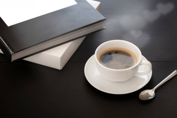 istock White ceramic coffee mugs and coffee beans over a black wooden table. 1135346121