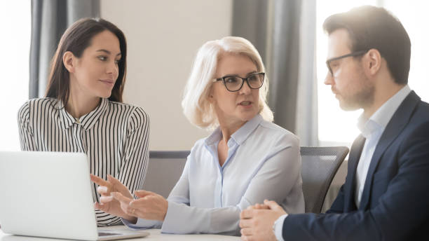 istock Old female leader speaking mentoring with computer at group meeting 1135346313