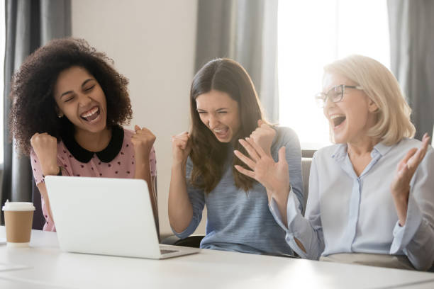 istock Diverse happy overjoyed female employees team excited by online win 1135346332