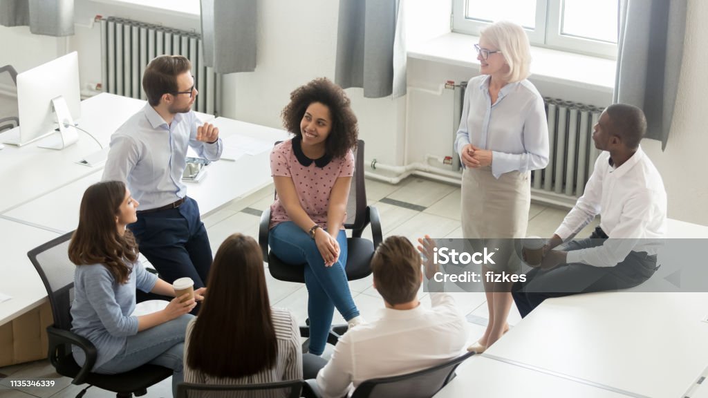 Business people group discussing work plan with coach at meeting Business people employees group discussing work plan with coach mentor at corporate office meeting, multicultural workers sales team talking at company workshop training, top view overhead from above Organized Group Stock Photo