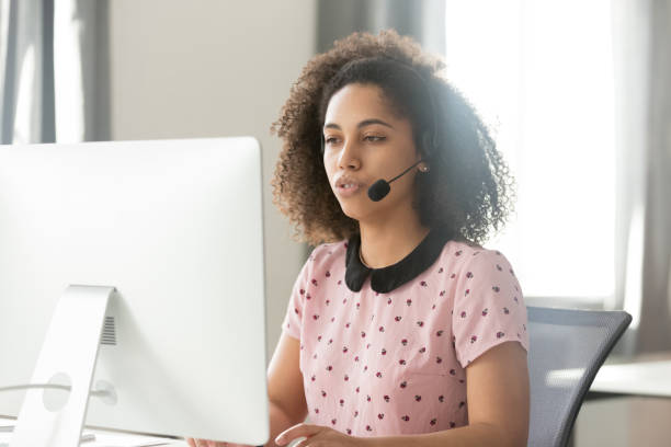 african call center operator in wireless headset talking using computer - center occupation headset on the phone imagens e fotografias de stock