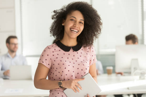 femme d'affaires africaine heureuse retenant la tablette numérique regardant l'appareil-photo - business women manager looking at camera photos et images de collection