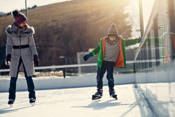 istock Mother teaching her son ice-skating on outdoors rink 1135348649