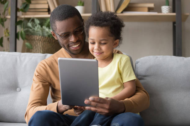 istock Happy african dad and little son using tablet at home 1135353580
