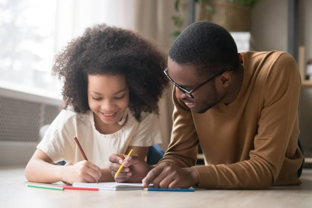 istock Caring black dad drawing with colored pencils teaching child girl 1135353623