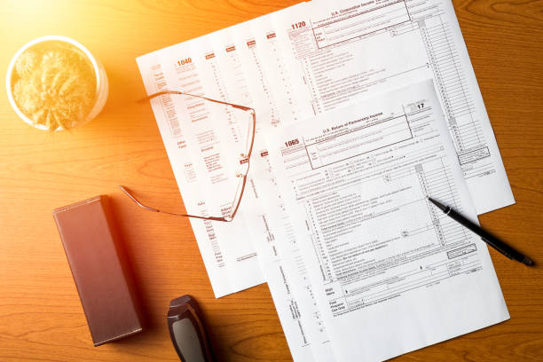 istock US tax forms 1040,1120,1065 on the table 1135353709