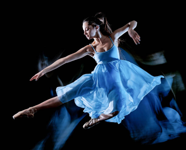 young woman ballet dancer dancing isolated black background light painting