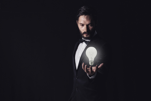 Businessman holding illuminated light bulb,