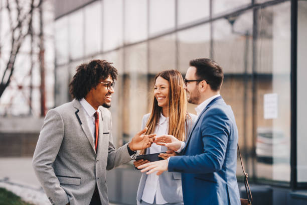 Three business colleagues walking outdoors and discussing.