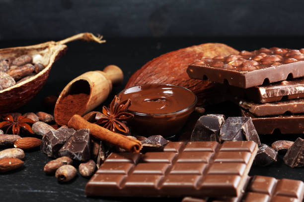 istock Melting chocolate or melted chocolate with a chocolate swirl and stack, chips and powder on black 1135356664