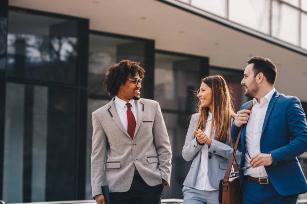 istock Three business colleagues walking outdoors and discussing. 1135356688