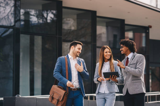 istock Smiling business colleagues walking outdoors and discussing. 1135356946