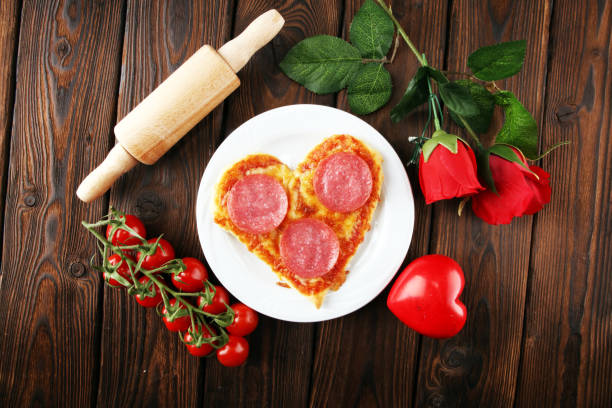 istock Valentines day pizza in heart shape on dark rustic wooden background. 1135357942