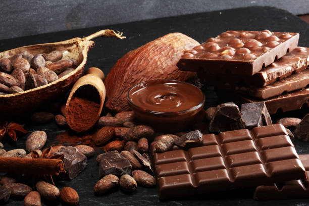 istock Melting chocolate or melted chocolate with a chocolate swirl and stack, chips and powder on black 1135361488