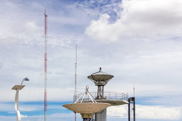 High technology satellite dish station and radio antenna pole on cloudy sky day