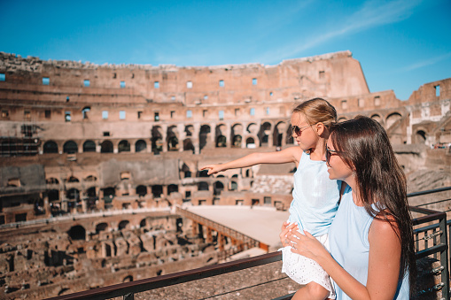 Family in Coliseum in Rome, Italy. Mother and little happy girl at famous place in Europe