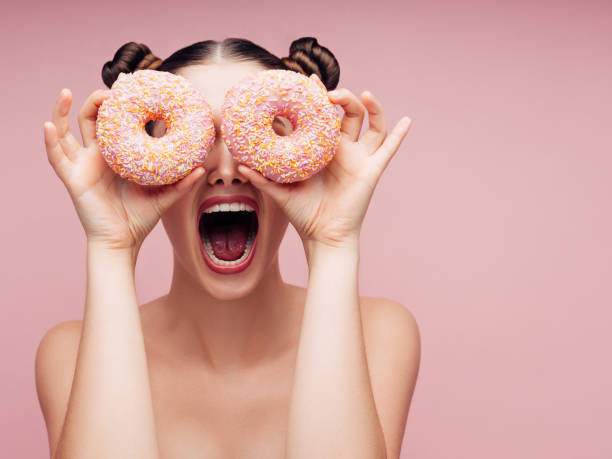 istock Young beautiful woman with donuts 1135364379