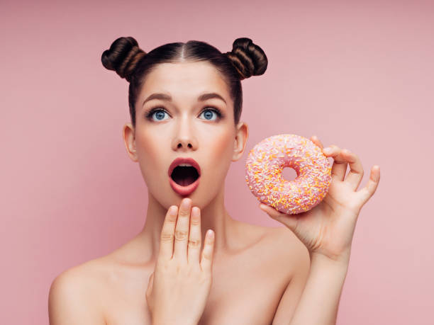istock Young beautiful woman with donuts 1135364454