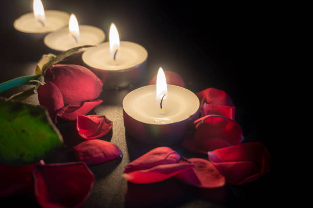 istock Four tea candles and rose petals in the dark 1135365545