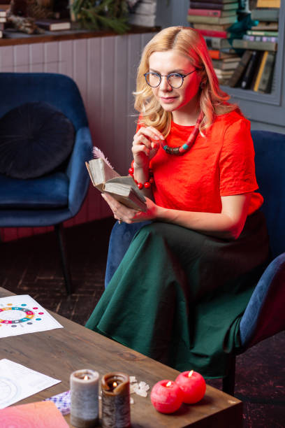 istock Blonde-haired fortune-teller feeling joyful reading interesting book 1135366712