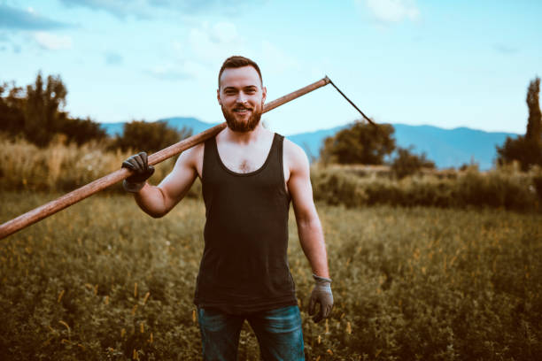 istock Male Lawn Mower Relaxing With Scythe After A Hard Day's Work 1135367973