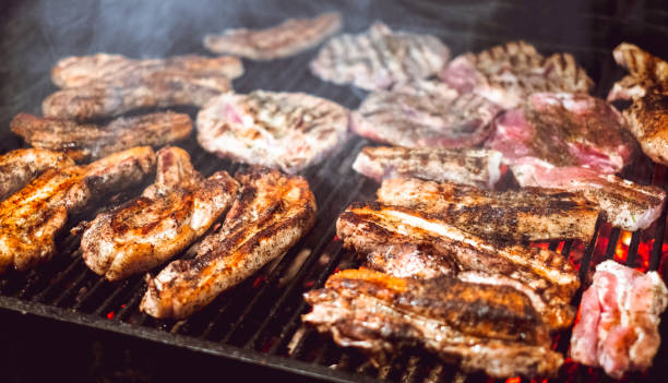 carne jugosa asada cocinada sobre los carbones en una barbacoa en la noche - charbroil fotografías e imágenes de stock