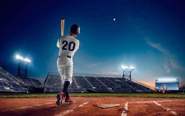 Baseball Baseball player at professional baseball stadium in evening during a game. baseball hitter stock pictures, royalty-free photos & images