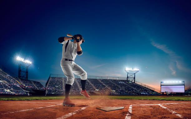 Baseball Baseball player at professional baseball stadium in evening during a game. pro baseball player stock pictures, royalty-free photos & images