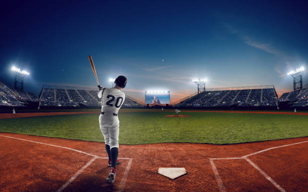Baseball Baseball player at professional baseball stadium in evening during a game. match sport stock pictures, royalty-free photos & images