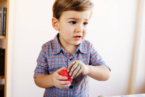istock Little boy holding red painted easter egg at home 1135372378
