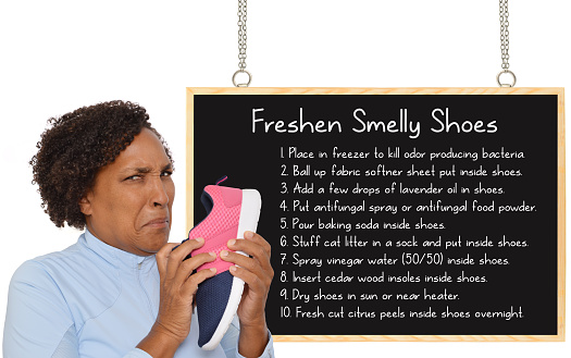 Woman making face smelling shoes blackboard with list of ways to Freshen Smelly Shoes white background
