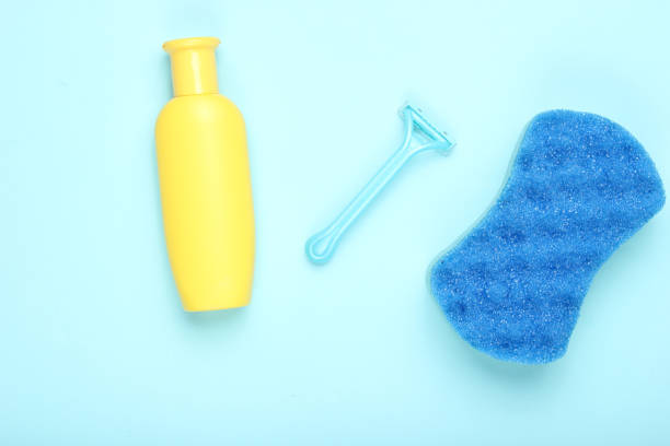 istock Epilator Razor, sponge, bottle shampoo on blue background. Bath concept, minimalism, top view, flat lay 1135376735